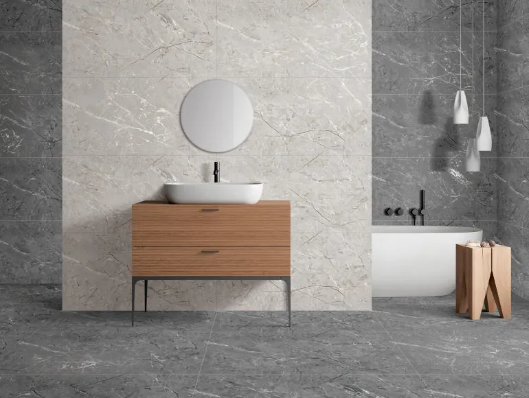 Stylish grey bathroom featuring sink with cabinets and round mirror